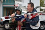 Kyle Reed helps to attach flag to the annual Christmas tree.